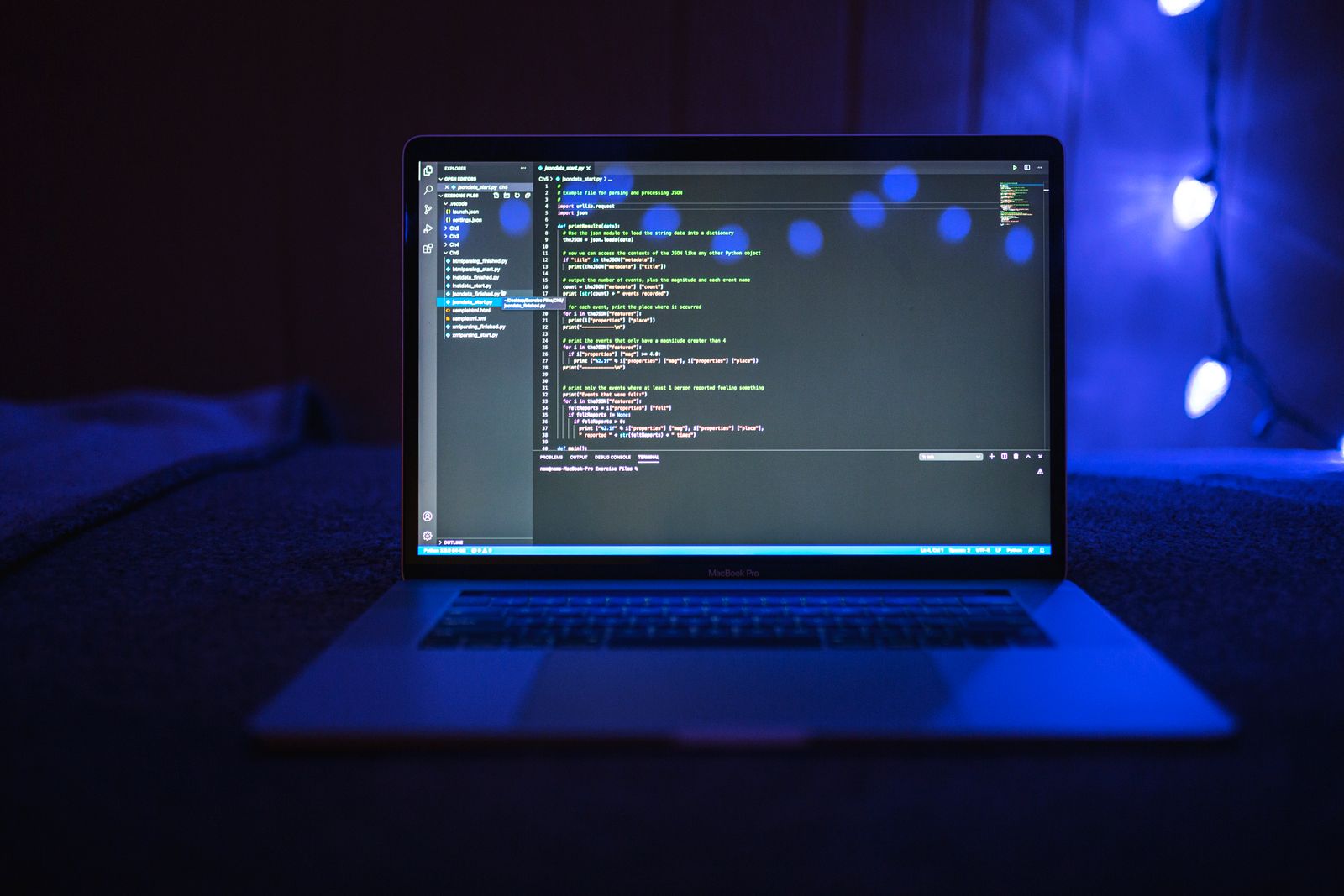 暗い空間でコードを表示するノートパソコン
